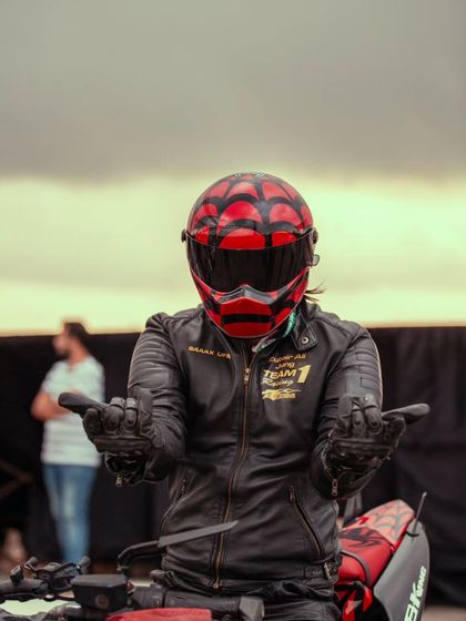 A stunt rider in a custom helmet, ready to put on a show for the crowd.