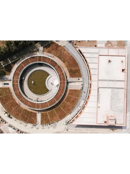 Another top-down view emphasizing the geometric purity of the circular sunken court and the surrounding green roof.