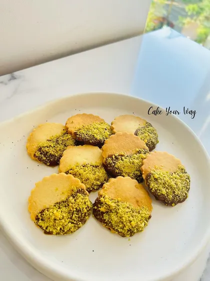 These are my pistachio sable cookies. They are a type of French butter cookie, incredibly rich and crumbly, dipped in chocolate and coated with crushed pistachios for a nutty, decadent finish.