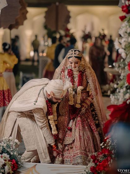 A moment of respect and tradition as the groom touches the bride's feet during the ceremony.