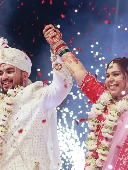 The moment of pure triumph and happiness. With hands raised high amidst a shower of confetti and sparks, this couple celebrates becoming husband and wife. A picture of pure, uncontainable joy.