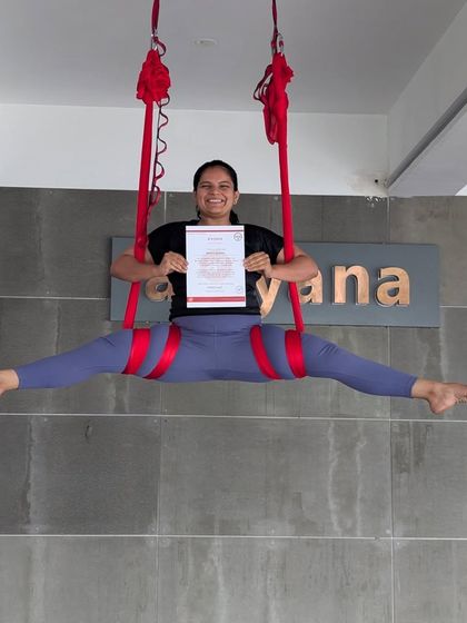 Flexibility, strength, and a huge smile. This student showcases a beautiful split in the aerial hammock, celebrating her certification.