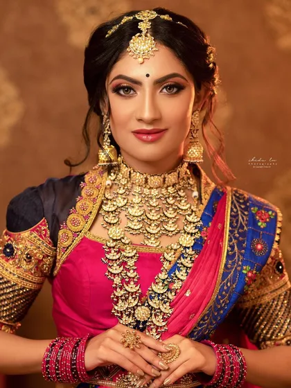 This close-up highlights a classic kasina sara, or coin necklace, a staple in South Indian bridal jewelry. Each coin is intricately detailed, and the set includes a matching choker and jhumkas, offering a timeless look of prosperity and heritage.