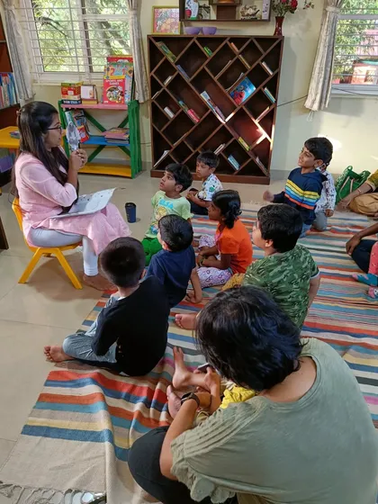 The storyteller asks the children questions about the story, encouraging critical thinking and discussion.
