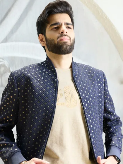 The navy bomber jacket with its textured weave and subtle gold detailing is perfect for adding a touch of sophistication to any outfit.