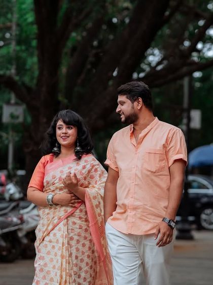 Another moment from the same city walk, capturing a natural smile and glance between the couple. The focus is entirely on their connection, with the busy street softly blurred in the background.