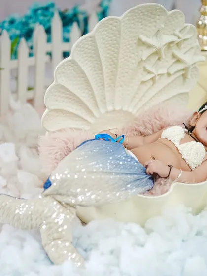 A big, happy laugh from this little mermaid, clearly enjoying her time in our whimsical seashell prop.