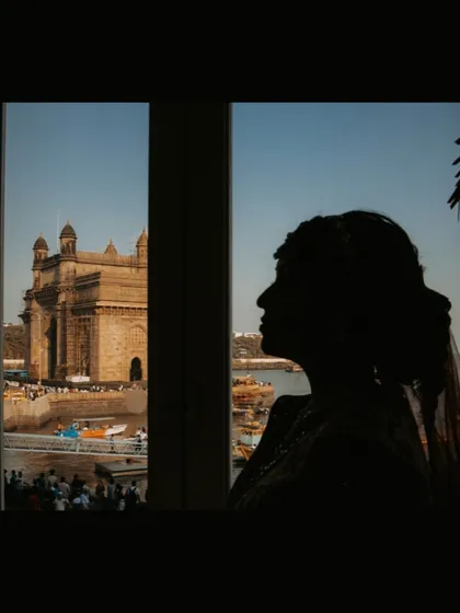 A silhouette of the bride looking out at the Gateway of India, a poignant and artistic shot taken before the festivities began.