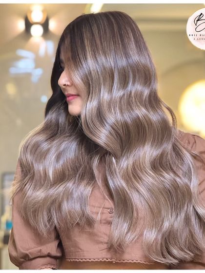 A side profile of the ash blonde look, with waves that perfectly highlight the cool, bright tones.