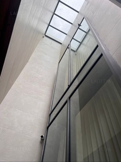An architectural detail showing a skylight atrium that floods the interior with natural light. We often use vertical windows and skylights to create dramatic, light-filled spaces and enhance the feeling of openness within the home.