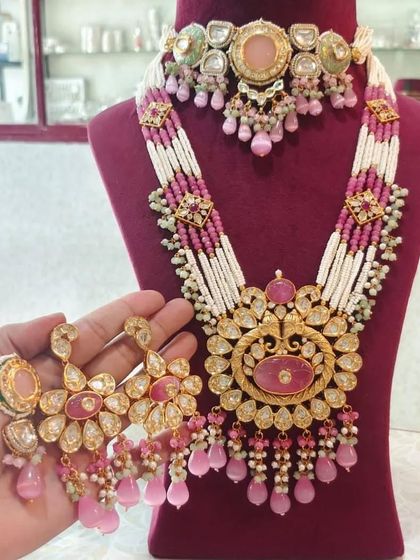 A grand bridal set with a pink and white beaded mala and a heavy kundan choker.