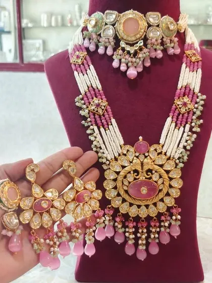 A grand bridal set in pink and white, featuring a choker and a long rani haar. This is a complete rental set with matching oversized earrings.