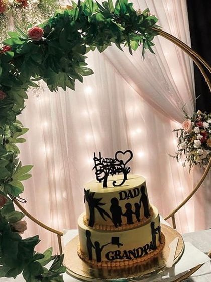 A close-up of the crescent moon cake stand. This unique stand, decorated with artificial leaves, provides a stunning and memorable way to display a cake for an anniversary, engagement, or other special event.