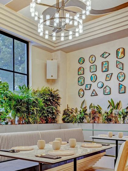 A wall of framed canvas paintings in a restaurant in Delhi.