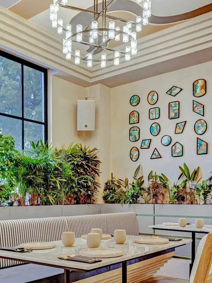 A wall of framed canvas paintings in a restaurant in Delhi.