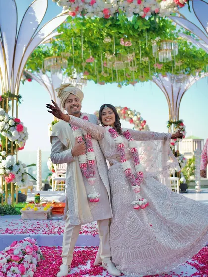 A fun, celebratory pose from the newlyweds on their petal-strewn stage. We encourage couples to be themselves and capture their true personalities.