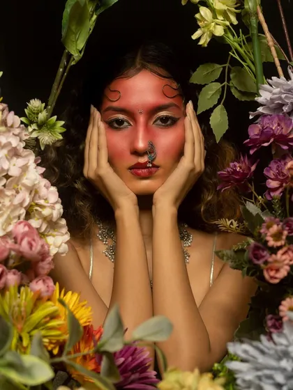 A close-up of the artistic red makeup, framed by flowers. This type of high-concept editorial work allows me to play with color, texture, and placement beyond traditional makeup.