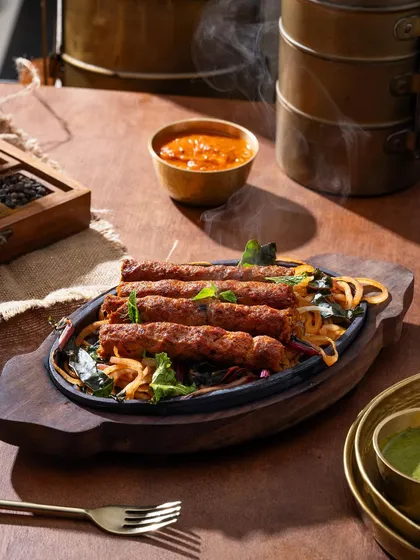 Sizzling hot kebabs on a platter. The rising steam communicates that the dish is fresh off the grill and ready to eat.