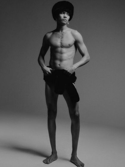 A full-body minimalist shot from the same editorial. The styling is provocative and bold, focusing on the model's form and creating a high-fashion, artistic statement.