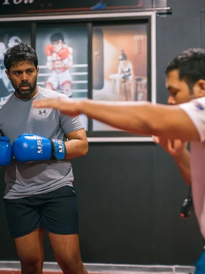 Discipline is the key to success. Here, a coach and student work on boxing drills, showing the focus required even when motivation is low.
