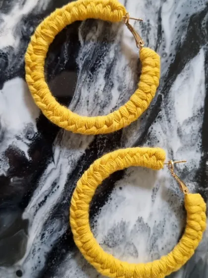 Brighten up your look with these sunny yellow macrame hoop earrings. They are a cheerful and fun accessory for any occasion.