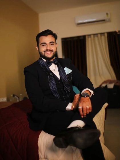 A relaxed shot of the dark blue suit with hexagon detailing. Even when seated, a bespoke suit holds its shape and ensures you look sharp.