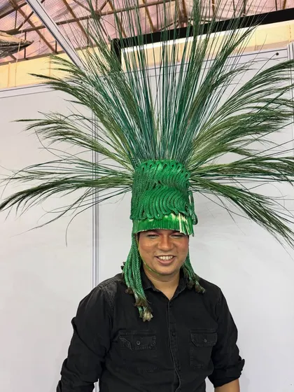 A close-up of one of the incredible, nature-inspired headpieces from our show. This piece was crafted to look like a vibrant, exploding palm, showcasing hair as a sculptural medium.