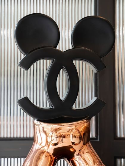 A close-up of the Chanel logo that forms the head of the "Chanel Mickey" sculpture, a powerful symbol of brand culture.