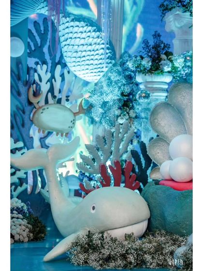 A close-up of the detailed props, including a cute whale nestled among coral and a friendly crab. The craftsmanship of these pieces is central to creating a believable, magical world.