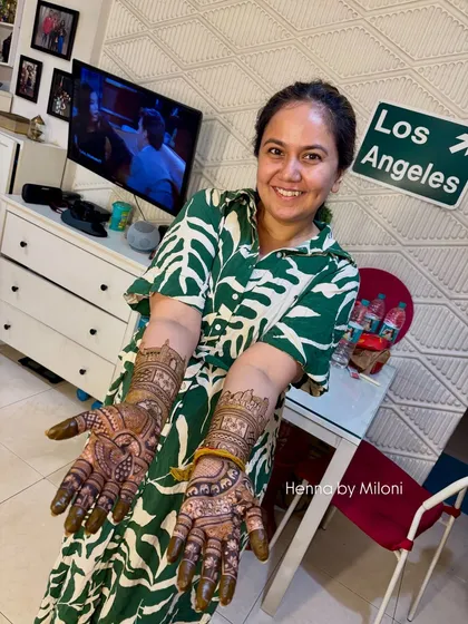 Happy client Roopal Tyagi showing off her beautiful mehendi. The design tells the story of her journey, and the stain is a testament to the quality of the paste.