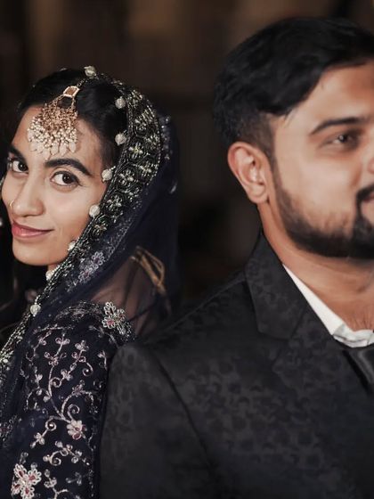 A stylish portrait of a couple at their reception, with the bride looking coyly at the camera.