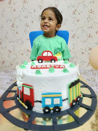 The birthday boy enjoying his custom train-themed cake, a testament to happy clients.