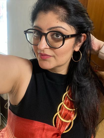 A close-up of the accessories. Simple gold hoops and my everyday watch are all that's needed to complement this bold saree look, letting the outfit itself be the star.