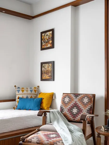 Another nook in the 'Gulmohar' family space, with a platform lounge seat and a comfortable armchair, creating a cozy corner for relaxation.