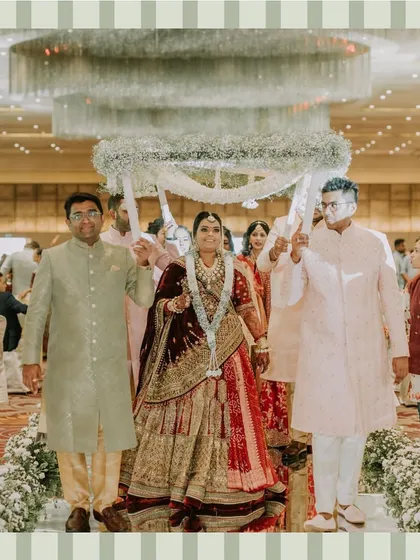 The bride makes her grand entrance under a beautiful floral canopy held by her brothers. A moment filled with family love and tradition.