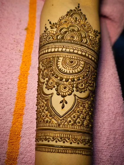 A close-up of the intricate armband, featuring swirls, dots, and a central mandala-like element.