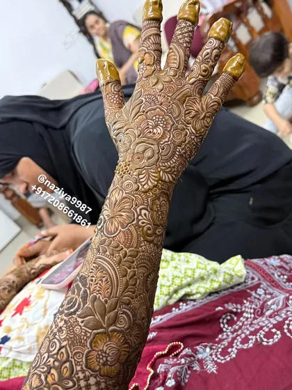 A detailed shot of the back of the hand for a bridal design. The pattern is dense and rich, featuring roses and fine-line fillers.