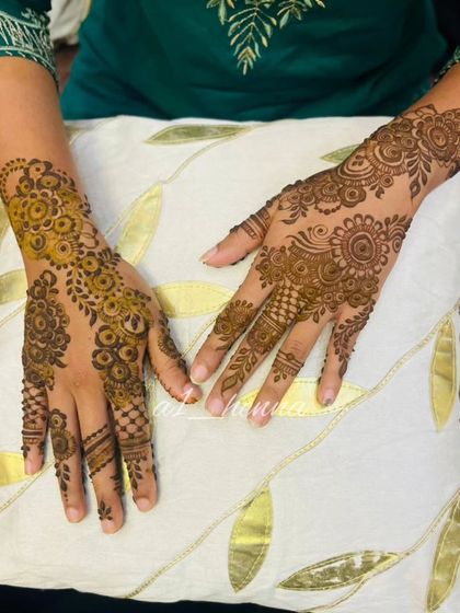 A pair of hands showcasing a matching Arabic design.