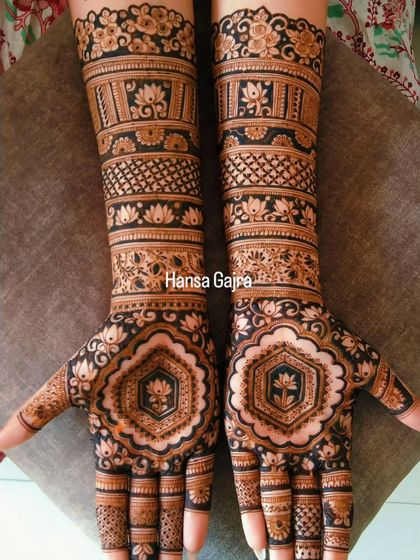 A classic engagement design with a modern touch. The hexagonal lotus motif on the palm is a unique element, surrounded by traditional bands of floral and jaali patterns for a full, elegant look.