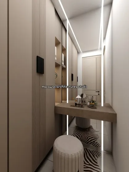 A compact walk-in closet or dressing area, designed for maximum efficiency. The space includes full-length wardrobes and a floating vanity table with integrated lighting.