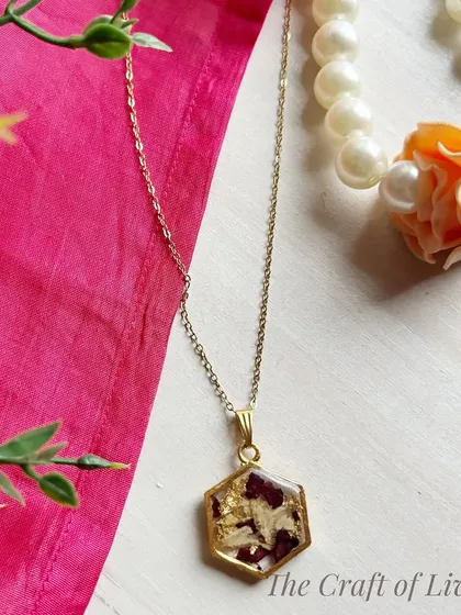 A hexagonal pendant with preserved petals and gold flakes. The geometric shape gives this piece a contemporary feel, perfect for everyday wear.