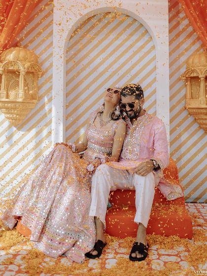 A relaxed and happy portrait of the couple enjoying a moment together during their vibrant Mehendi ceremony.