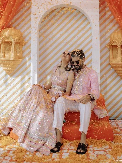 A relaxed and happy portrait of the couple enjoying a moment together during their vibrant Mehendi ceremony.