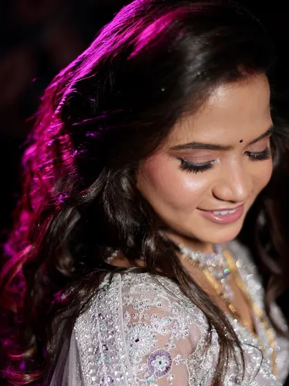 A close-up shot of the bride's reception makeup. The soft lighting highlights the shimmer on her eyes and the glow on her skin.