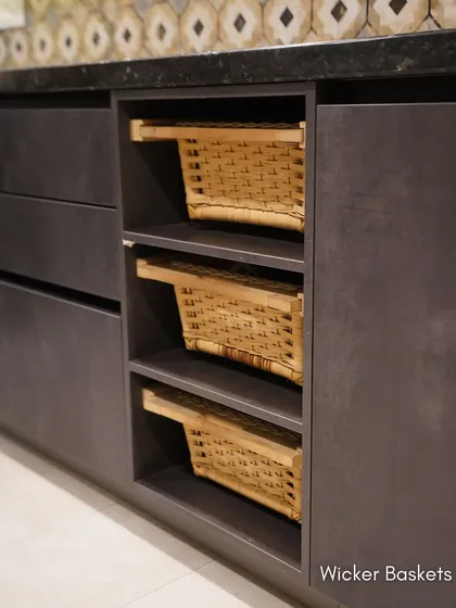 A detail of the open shelving with wicker baskets, a practical solution for storing vegetables that also adds a natural, rustic touch to the modern design.