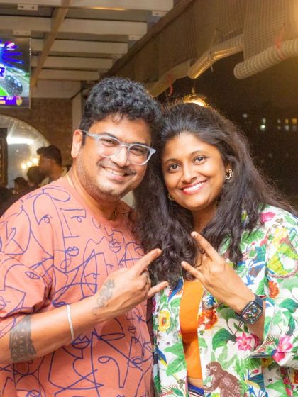 A couple enjoying the vibrant atmosphere at the pub. The live cricket match playing on the screen behind them adds to the energetic vibe of the evening.
