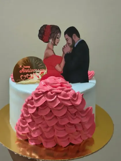 A romantic anniversary cake featuring a beautiful illustration of a couple and an intricate buttercream dress design.