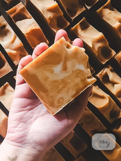 Holding a single, freshly cut bar with a beautiful swirl. This is a piece of captured luxury, with ingredients so good they will transform your daily shower into a special ritual.