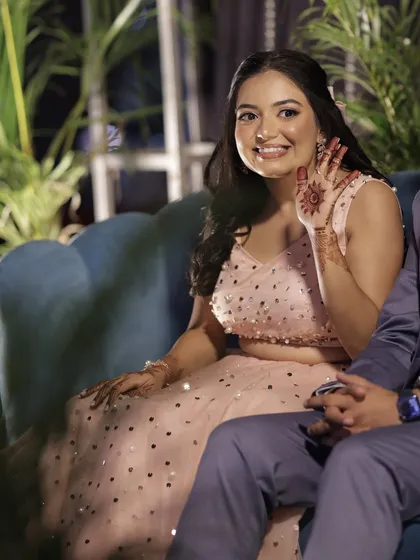 Waving to her guests with a happy heart. The makeup is fresh and radiant, perfect for a night of celebration.