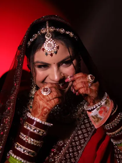A playful and shy moment from the bride, captured against a dramatic red light. It shows a different side of her personality.